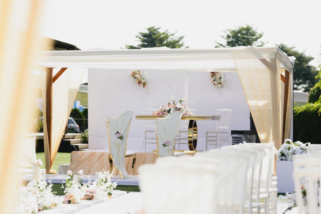 Beautiful outdoor wedding ceremony setting with white and pastel-colored decor and floral arrangements.